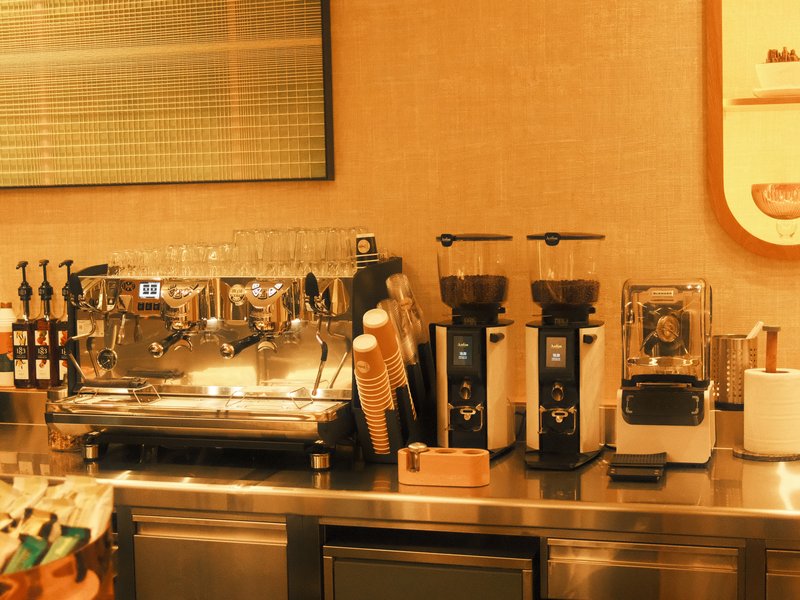 A coffee bar setup featuring espresso machines, grinders, and various coffee accessories.
