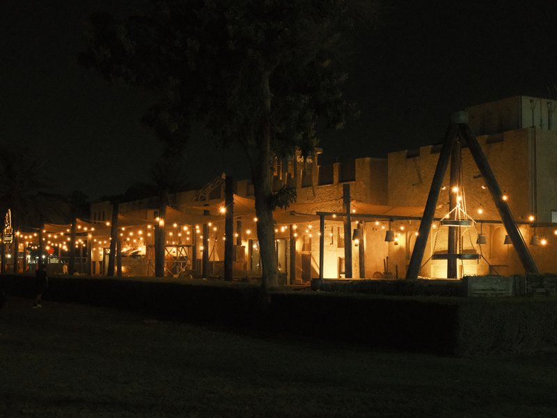 A dimly lit outdoor restaurant with string lights illuminating the patio area at night.
