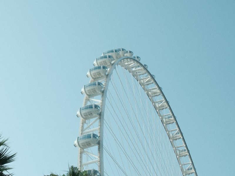 A close-up view of a large ferris wheel against a clear blue sky.