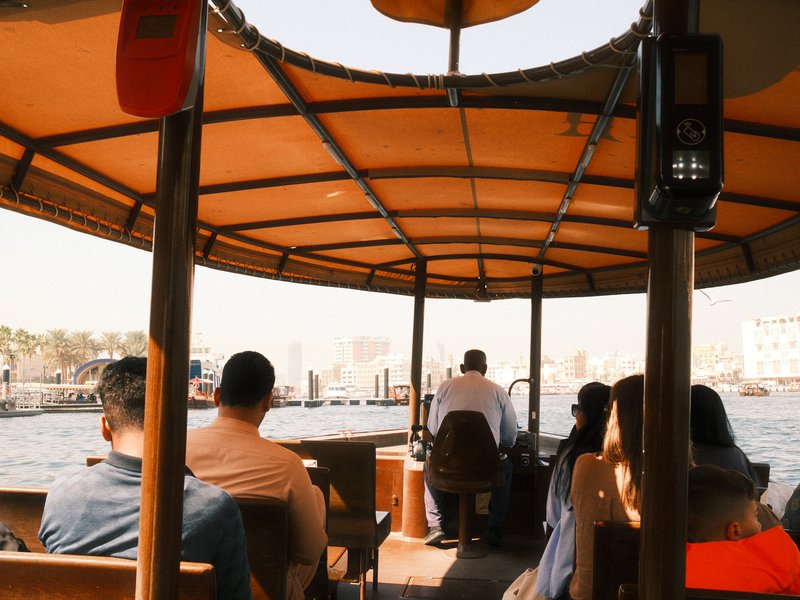 Passengers on a boat enjoying a scenic view of the waterfront city.