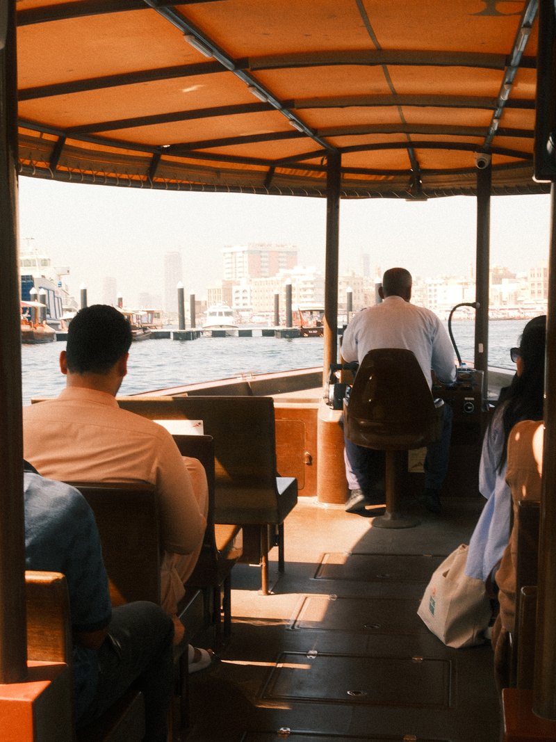 View from inside a boat with passengers seated, navigating through a city waterway.