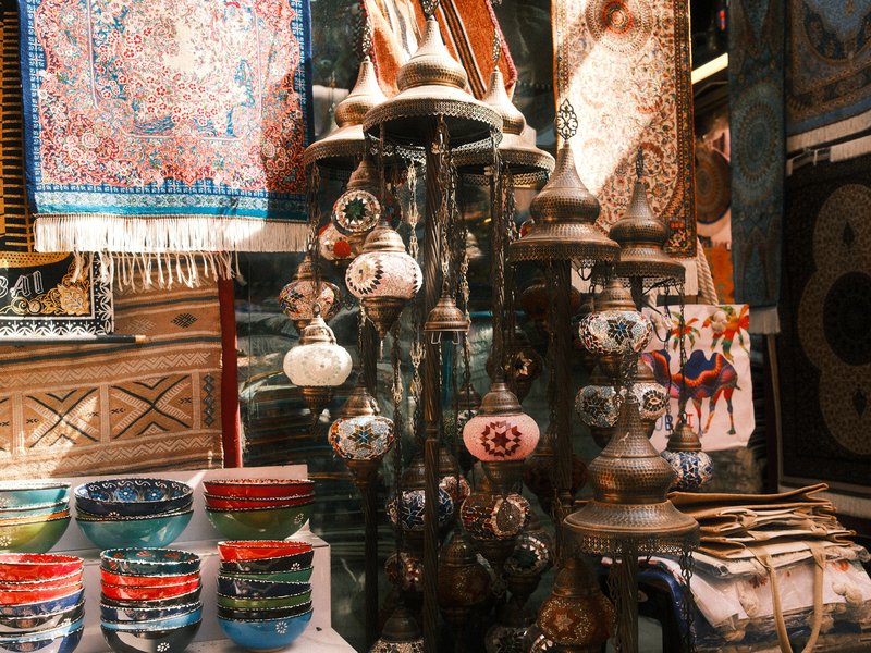 Colorful pottery and decorative items displayed in a market setting with intricate patterns.