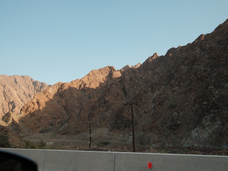 Mountainous landscape with rocky terrain and shadows cast by the setting sun.
