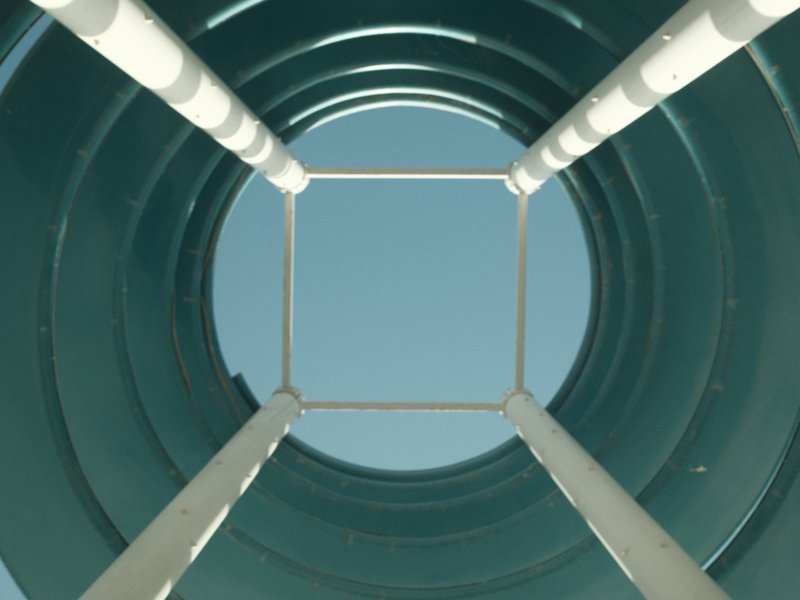 Looking up through a circular structure with a clear blue sky above.