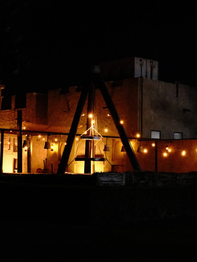 A rustic building illuminated by warm lights at night, creating a cozy atmosphere.