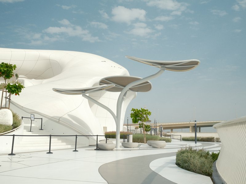 Modern architectural structure with unique design elements and greenery under a blue sky.