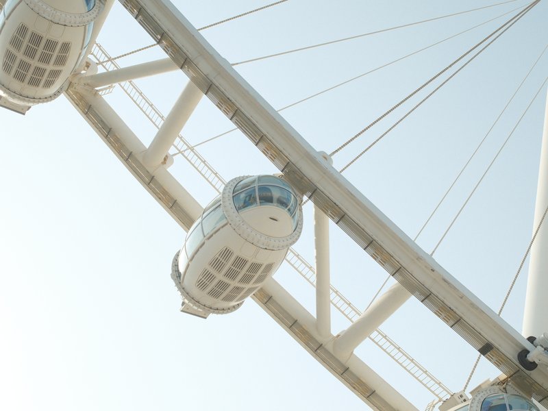 Close-up view of a ferris wheel cabin against a clear sky.
