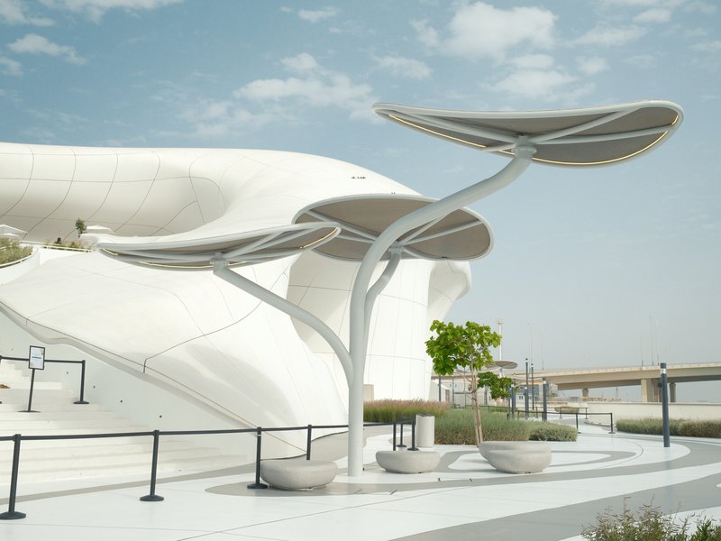 Modern architectural structure with unique leaf-like canopies against a cloudy sky.