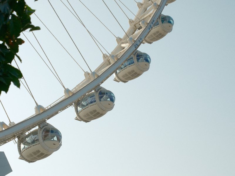 Close-up of a ferris wheel with several cabins against a clear sky.