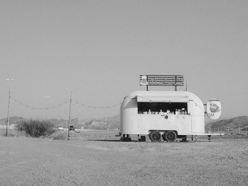 A vintage food trailer in a barren landscape under a clear sky.