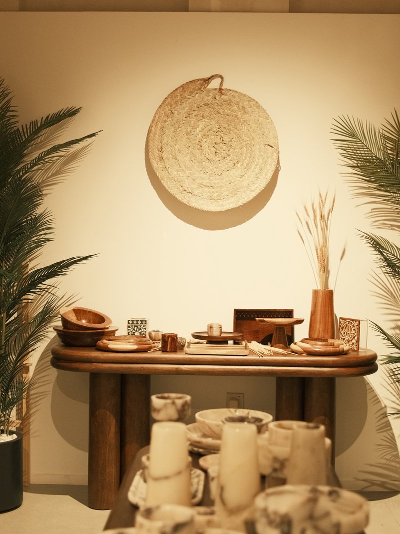 A cozy interior scene featuring a wooden table adorned with various pottery and decorative items.