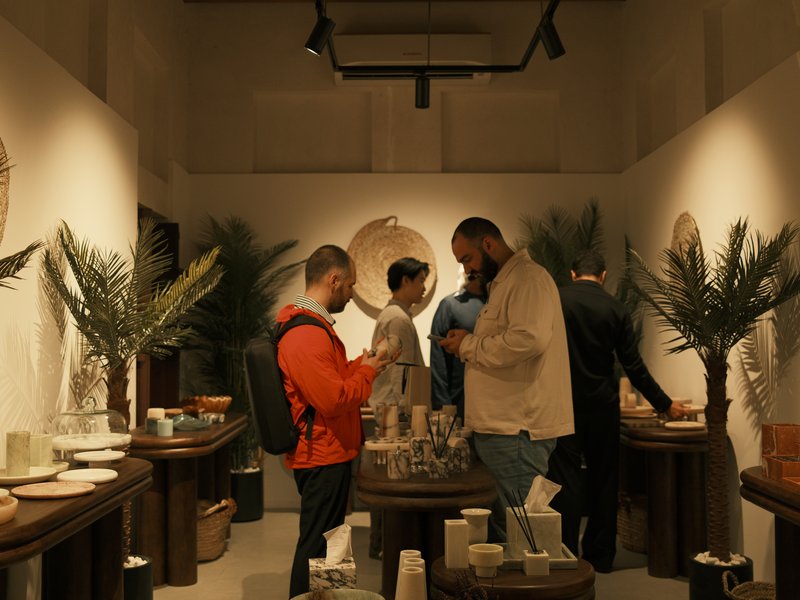 A group of people exploring a stylish indoor shop filled with decorative items and plants.