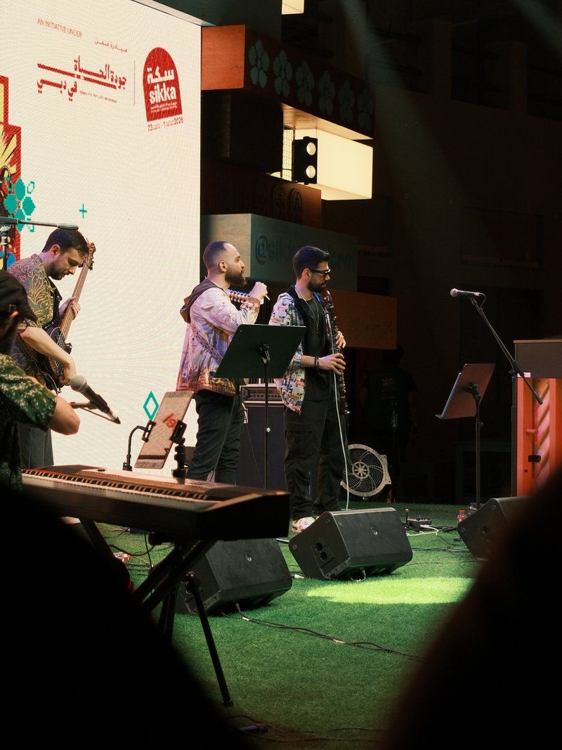 A band performing on stage with musicians playing instruments in a vibrant indoor setting.