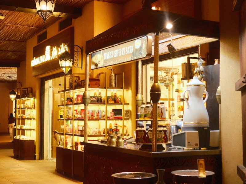 A cozy indoor market stall with shelves of products and warm lighting.