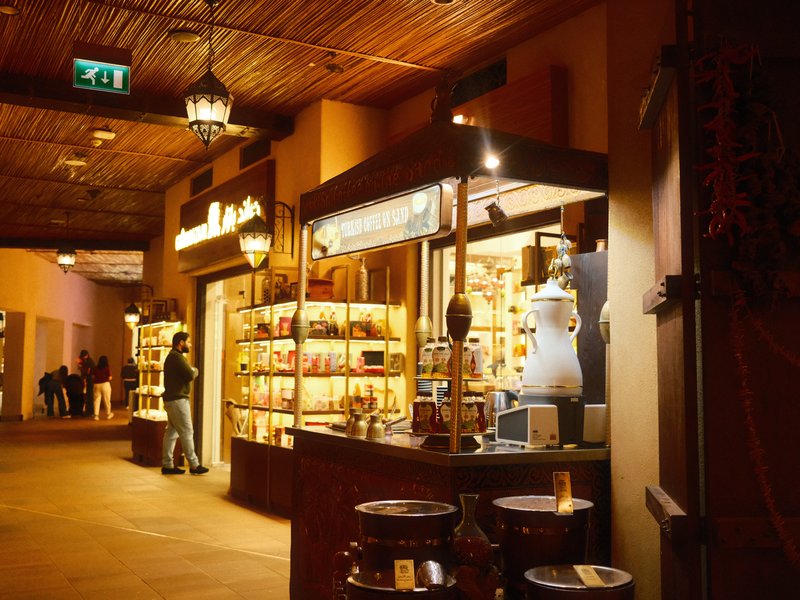 A cozy indoor market scene with a shop displaying various goods under warm lighting.