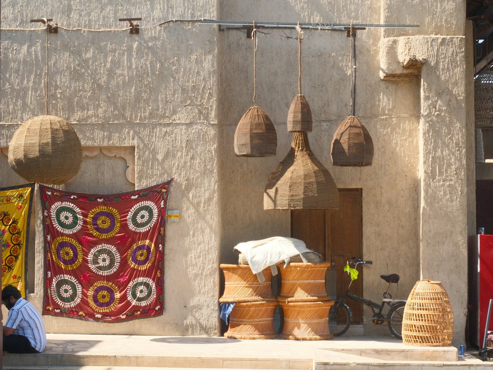 A rustic wall adorned with woven baskets and colorful textiles, showcasing traditional craftsmanship.