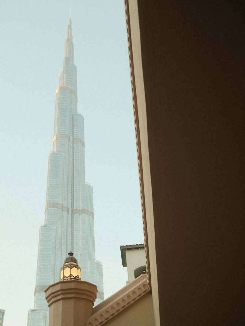 View of the Burj Khalifa towering above a building with a decorative lantern in the foreground.