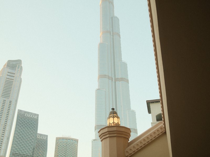 Tall skyscraper with a unique design rising above other buildings in a cityscape.
