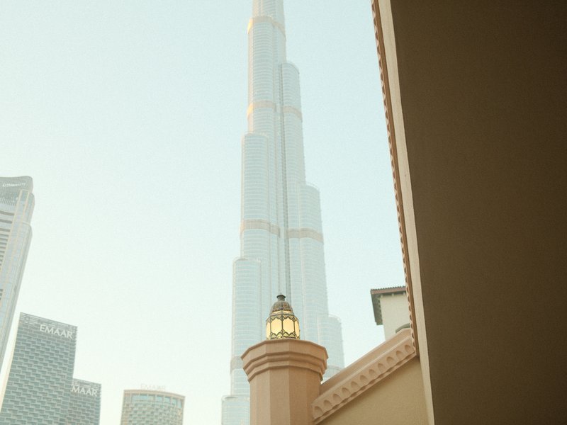 View of the Burj Khalifa tower from a nearby building, with a decorative architectural element in the foreground.