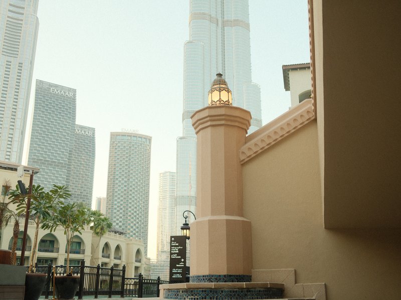 A tall building in the background with a decorative tower in the foreground, showcasing urban architecture.