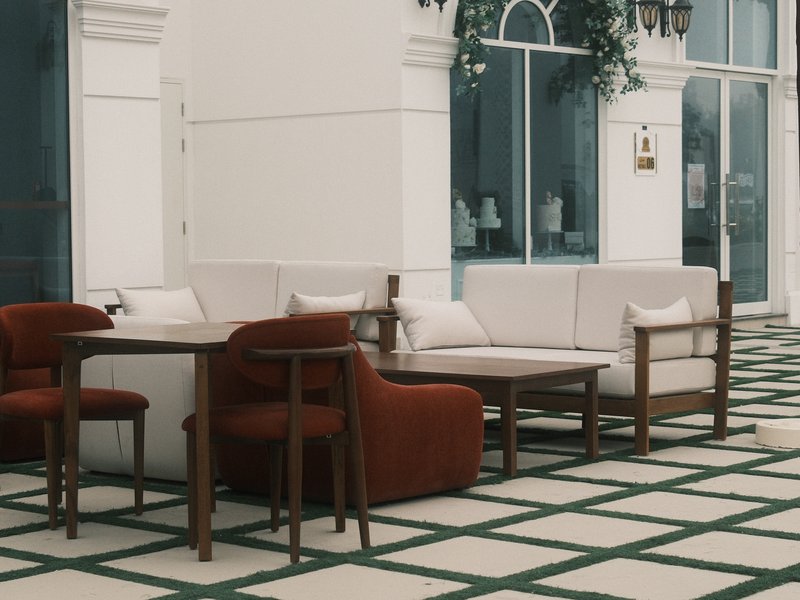 A cozy outdoor seating area with modern furniture on a patterned tiled floor.