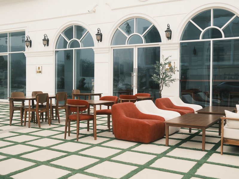 Outdoor seating area with various chairs and tables in a modern architectural setting.