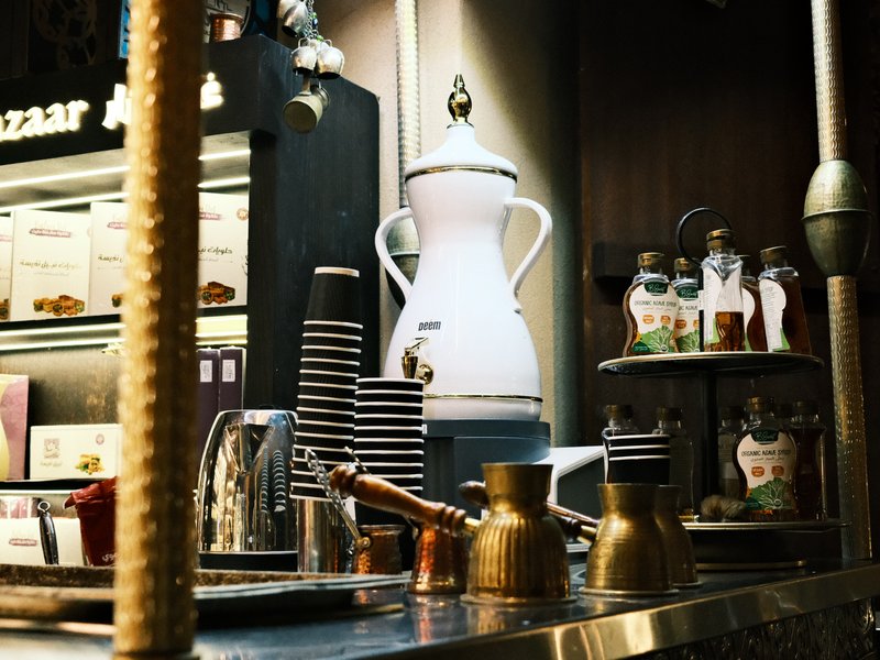 A cozy coffee shop counter with various coffee equipment and decorative elements.