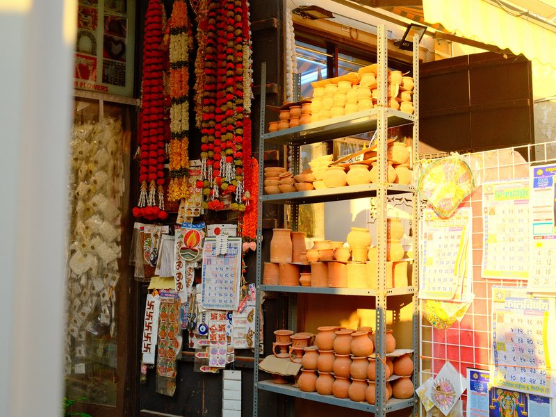 A vibrant display of clay pots and decorative items in a shop, illuminated by warm sunlight.