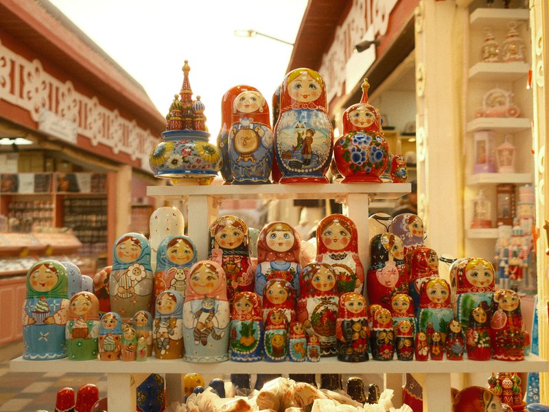 A colorful display of traditional Russian nesting dolls arranged on a shelf in a market.