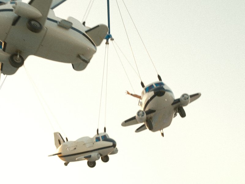 Three model airplanes suspended in the air against a pale sky.