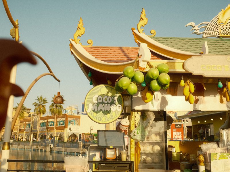 Colorful outdoor market scene with a vibrant food stall and decorative architecture.