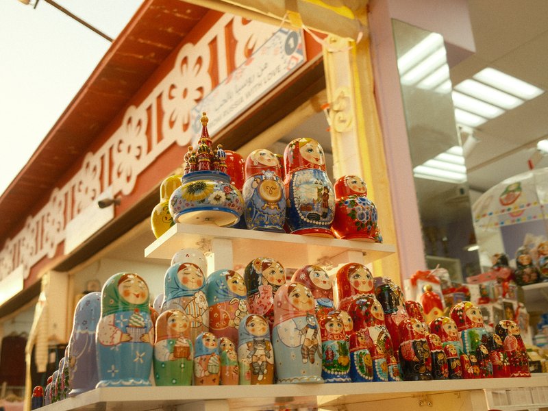 Colorful Russian nesting dolls displayed in a shop with a vibrant background.