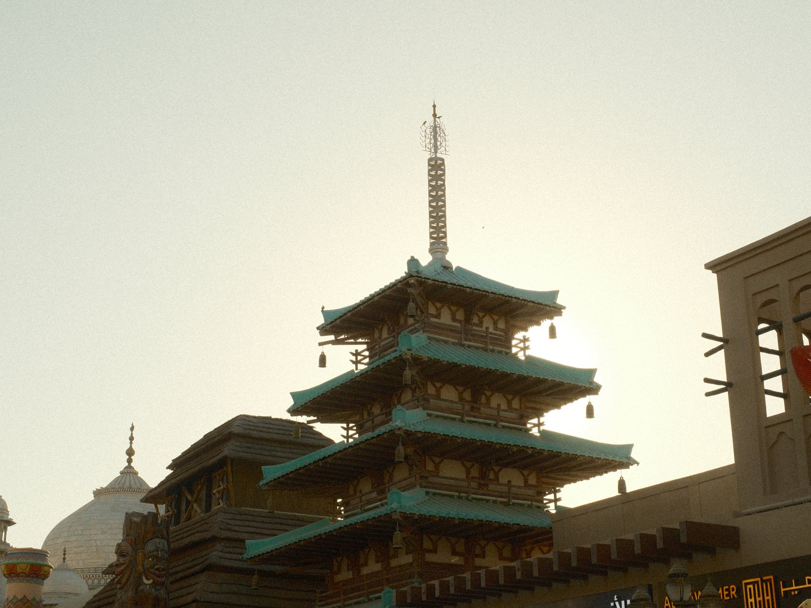 Silhouette of a pagoda against a bright sky, with architectural details visible.