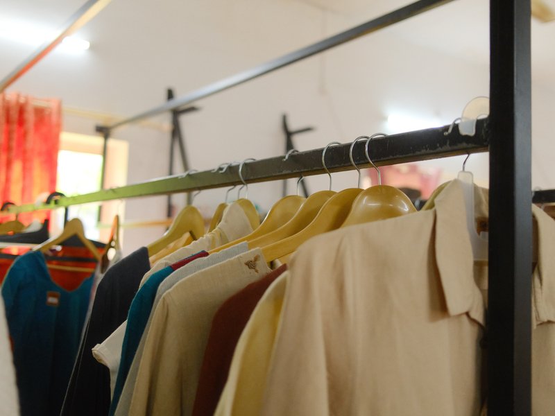 Clothes hanging on a rack in a bright indoor setting with soft lighting.