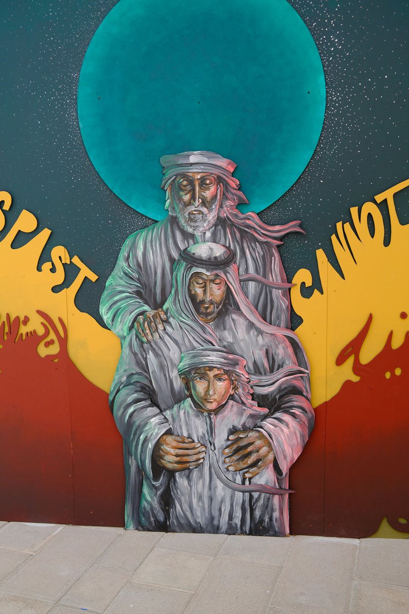 A colorful mural depicting three figures in traditional attire against a vibrant background with a large blue circle.