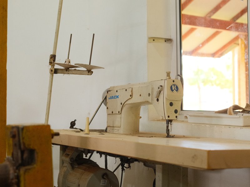 A vintage sewing machine on a wooden table near a window with natural light.
