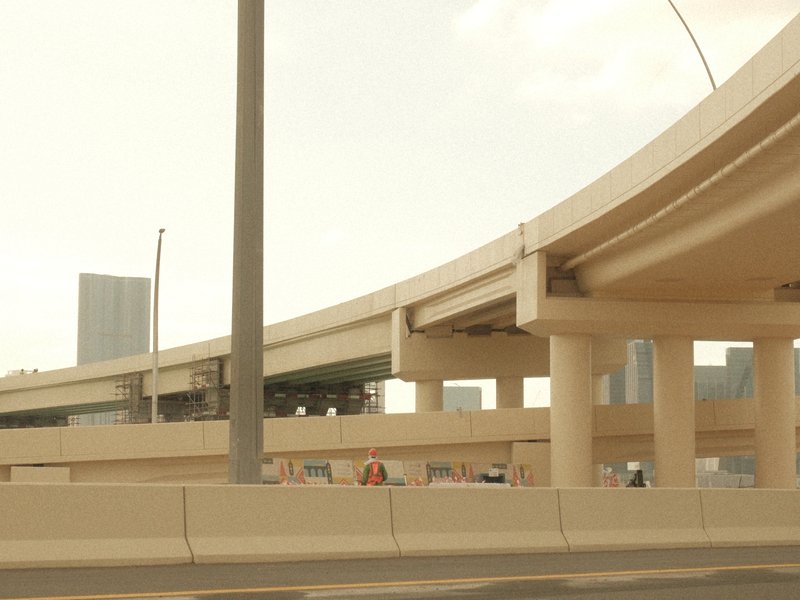 A view of a highway overpass with concrete structures and a hazy sky in the background.