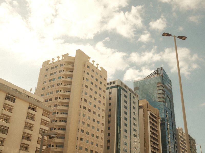 City skyline with modern and older buildings under a partly cloudy sky.