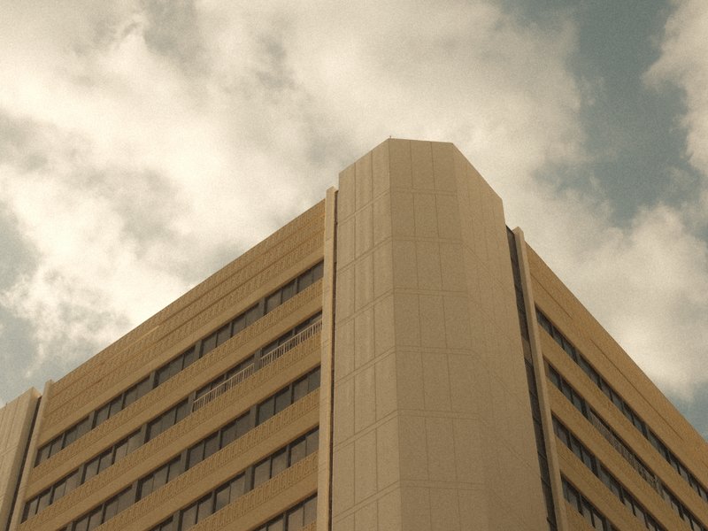 A close-up view of a modern building corner against a cloudy sky.