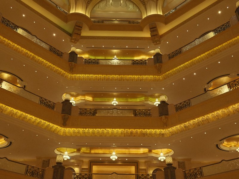 Interior view of a luxurious hotel lobby with multiple levels and ornate lighting.