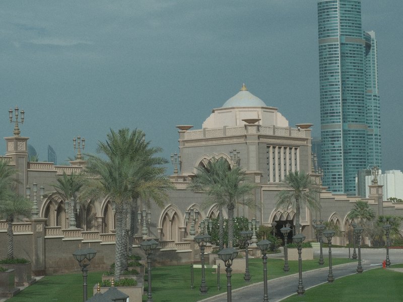 A blend of traditional and modern architecture featuring a grand building with a dome and a tall skyscraper.