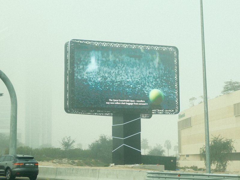 A large digital billboard displaying an advertisement in a foggy urban environment.