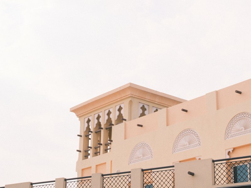 A close-up view of a building with traditional architecture against a pale sky.