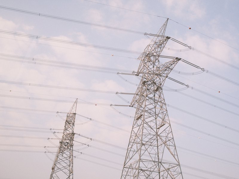 Power lines stretching across a pastel sky with soft clouds.