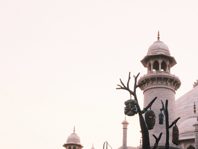 A historical building with intricate architecture and a pale sky in the background.