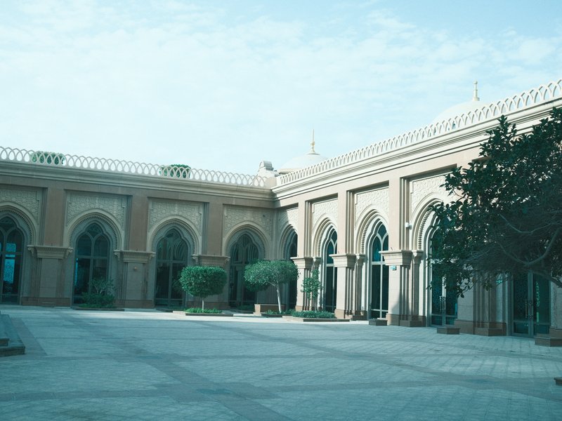 A serene courtyard of a historic building with arched windows and greenery.