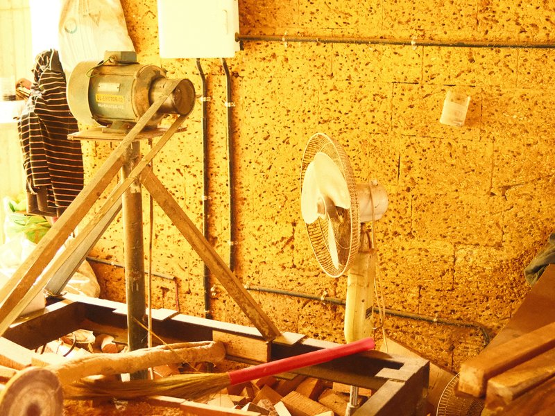 A woodworking workshop with tools and wooden shavings scattered on the floor.