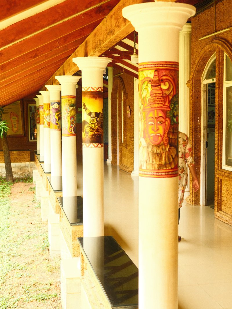 A corridor with decorative columns and a polished floor, showcasing artistic designs and a warm atmosphere.