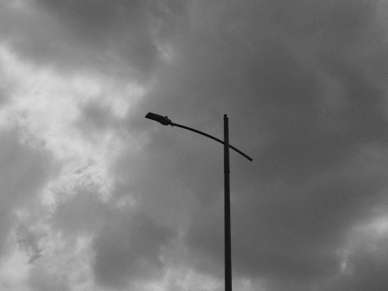 A solitary street lamp against a backdrop of dark, cloudy skies.