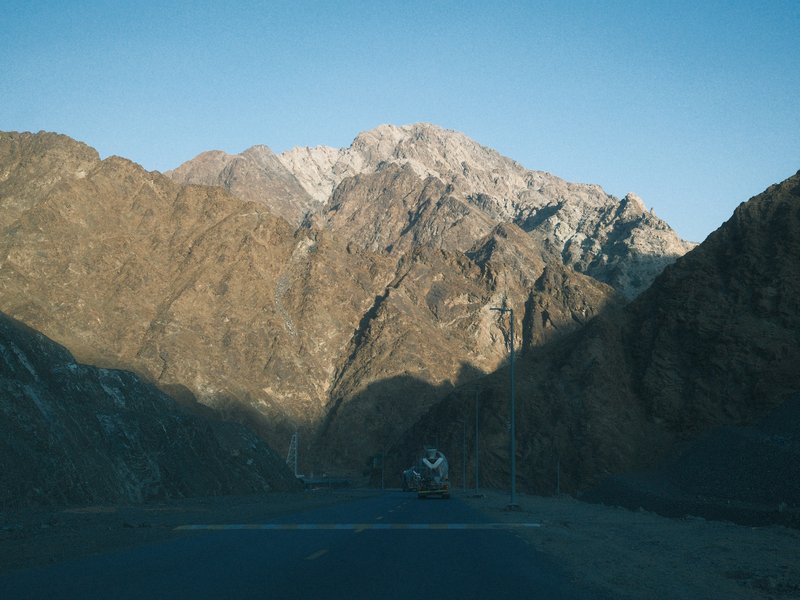 A winding road through rugged mountains under a clear blue sky.